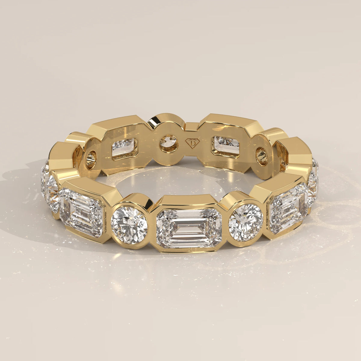 Emerald and Round Lab Grown Diamond Bezel Set Eternity Band in yellow gold, shown at an angle.