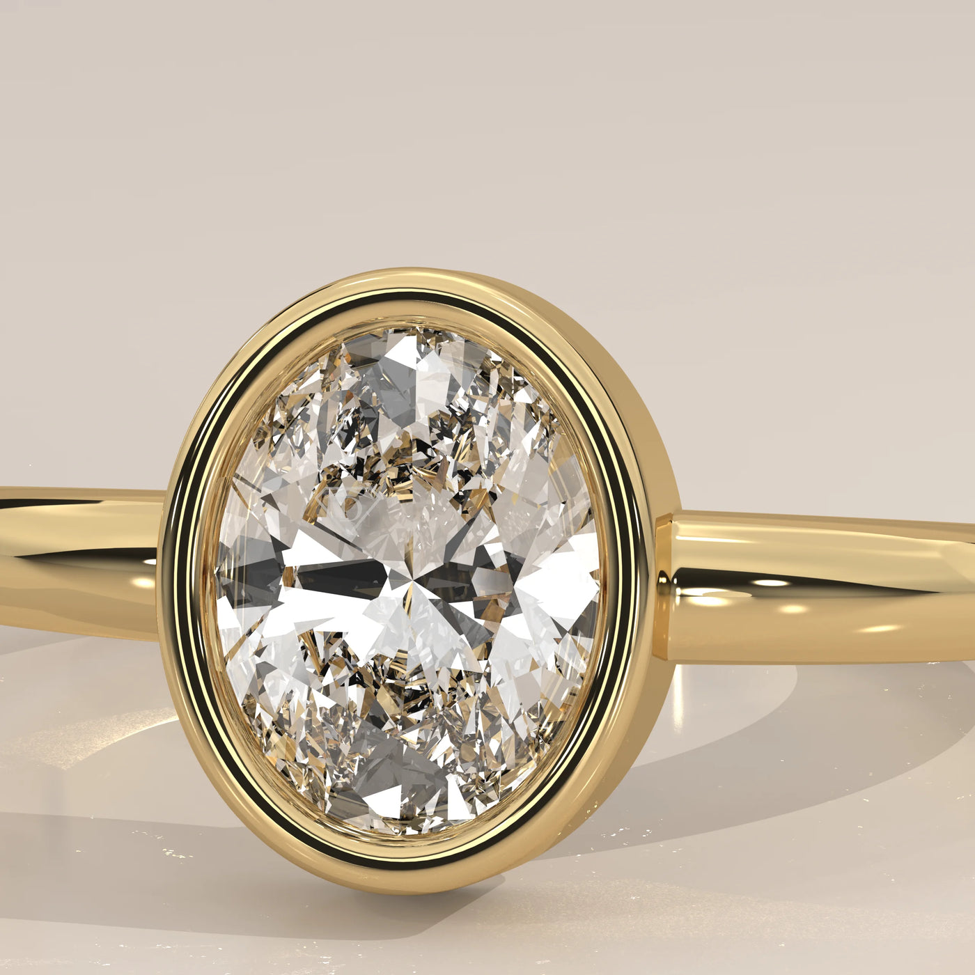 Oval diamond engagement ring with a yellow gold bezel setting.