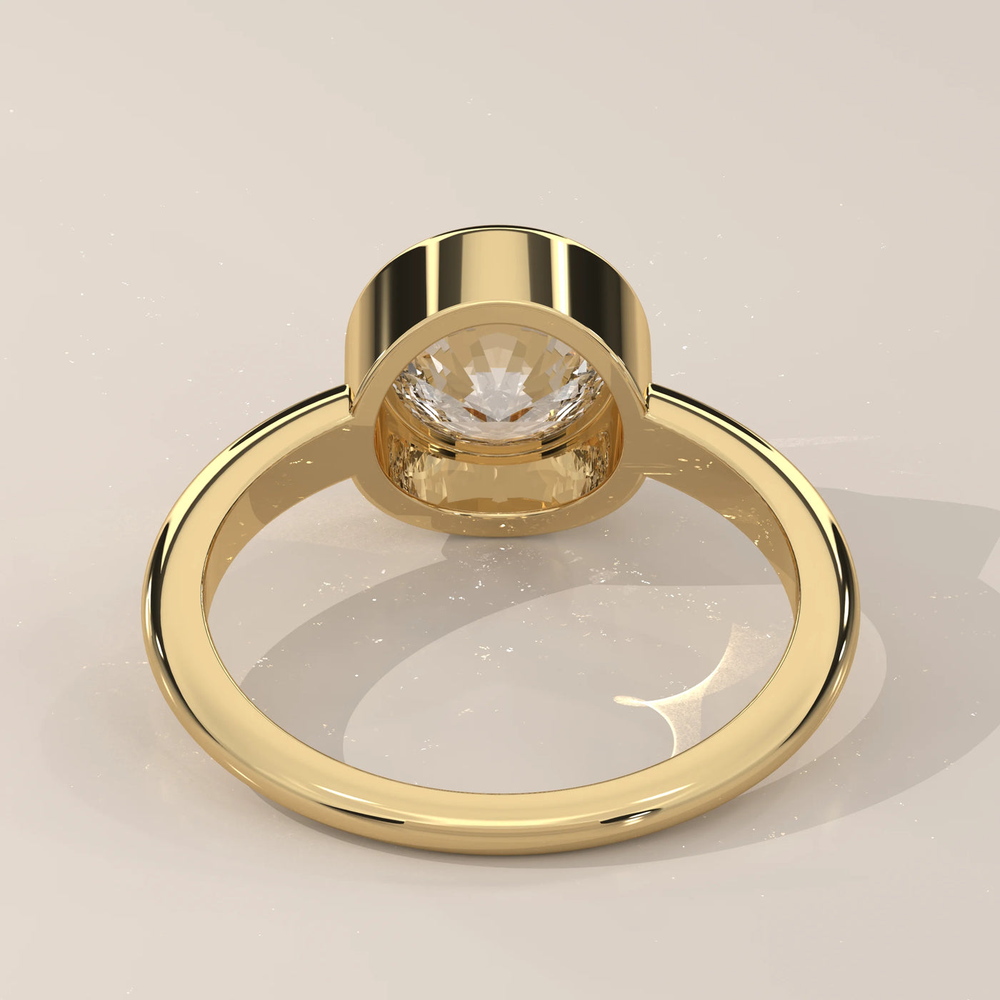 Gold ring with a round diamond set in a bezel setting.