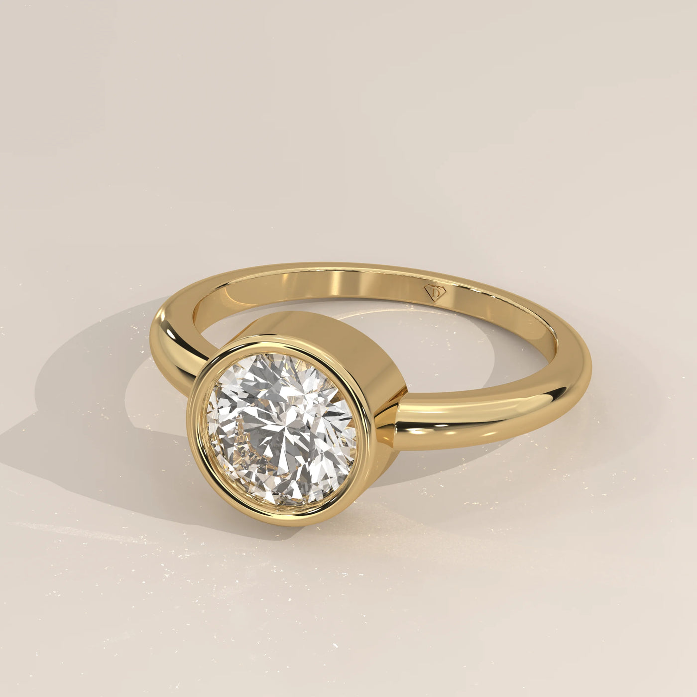 A solitaire diamond ring with a gold bezel setting and band.
