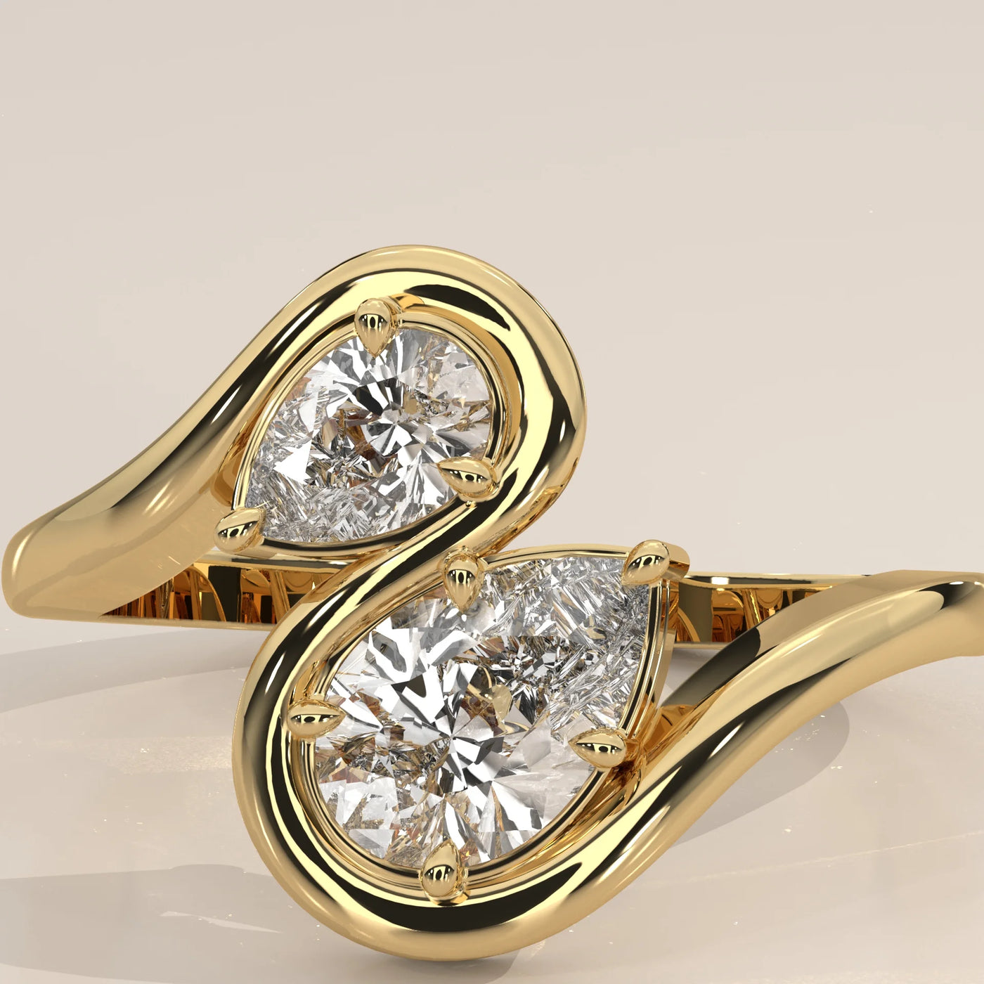 A yellow gold bypass ring with two pear-shaped diamonds.