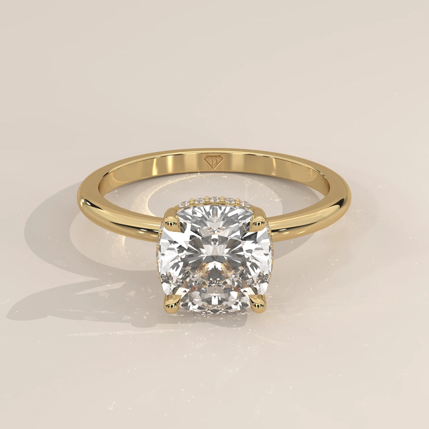 A yellow gold ring with a bezel-set cushion-cut diamond.