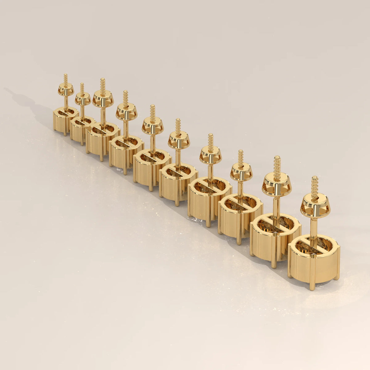 Gold screw-back earrings arranged diagonally on a light surface.