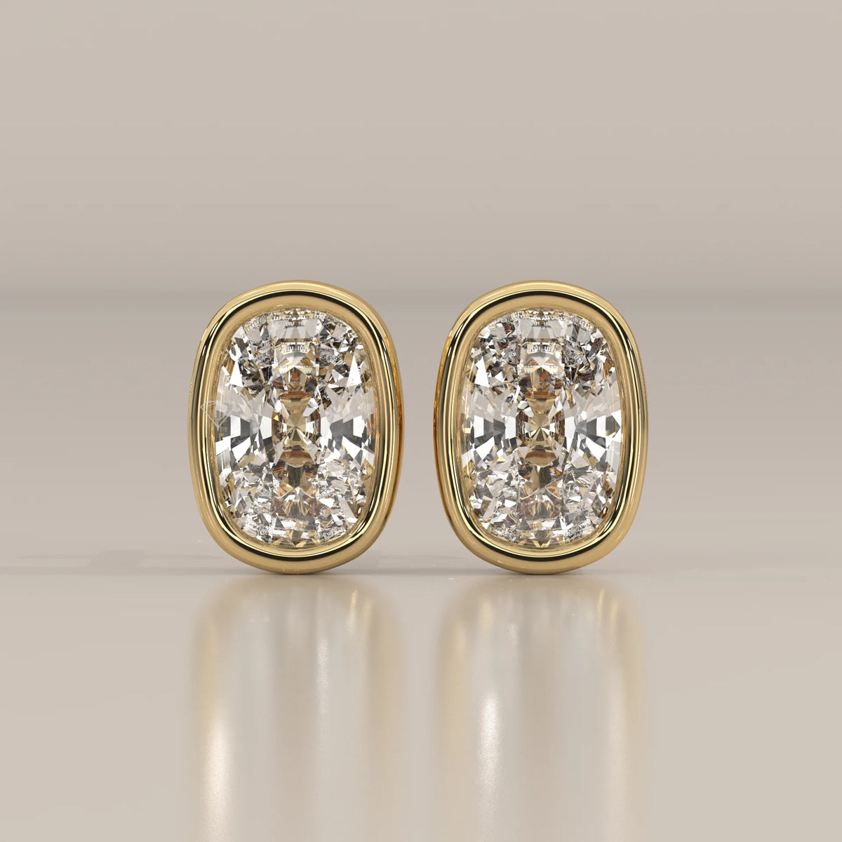 A pair of cushion-cut diamond stud earrings set in yellow gold.