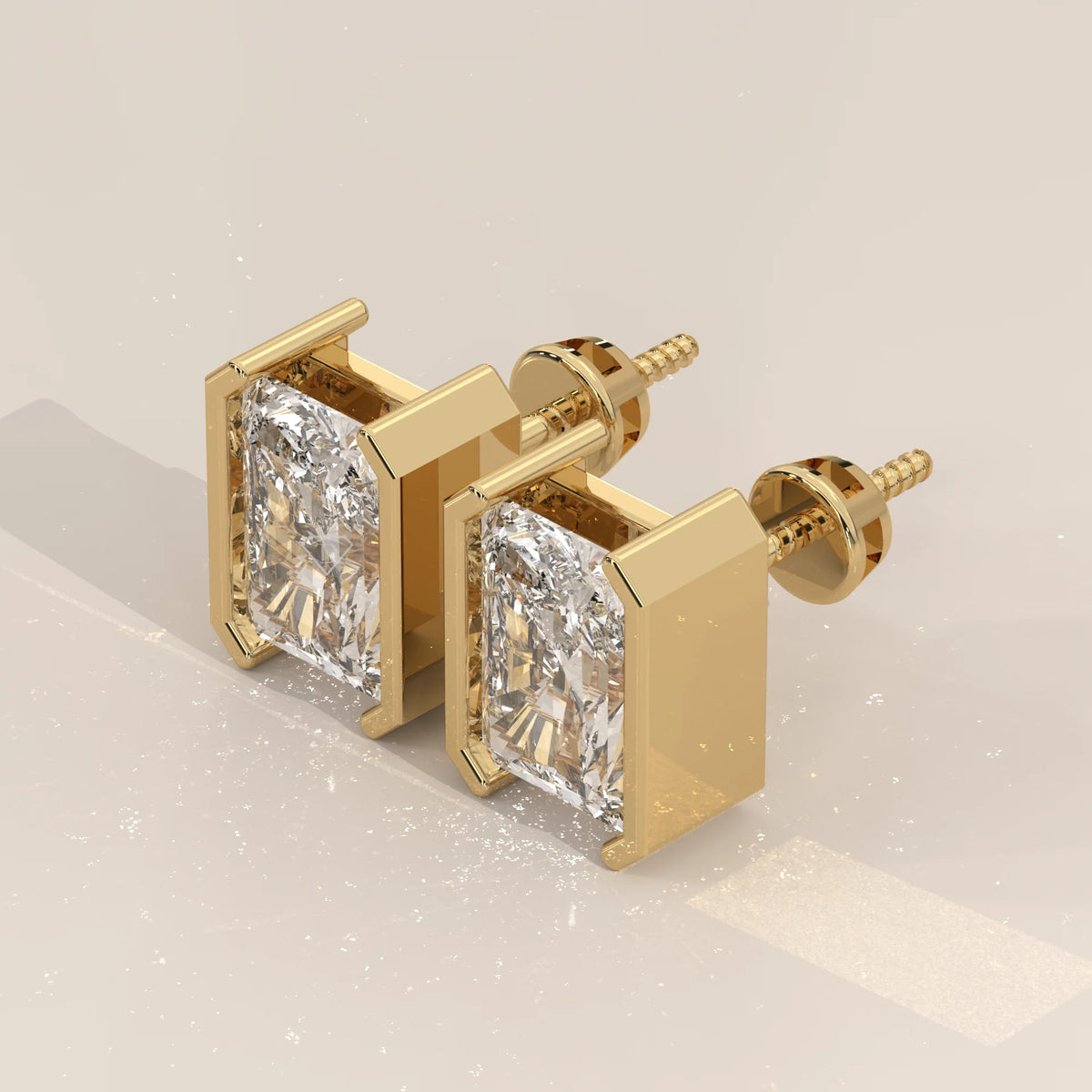 Elongated Radiant Half Bezel Lab Grown Diamond Stud Earrings in yellow gold, shown on a plain background.