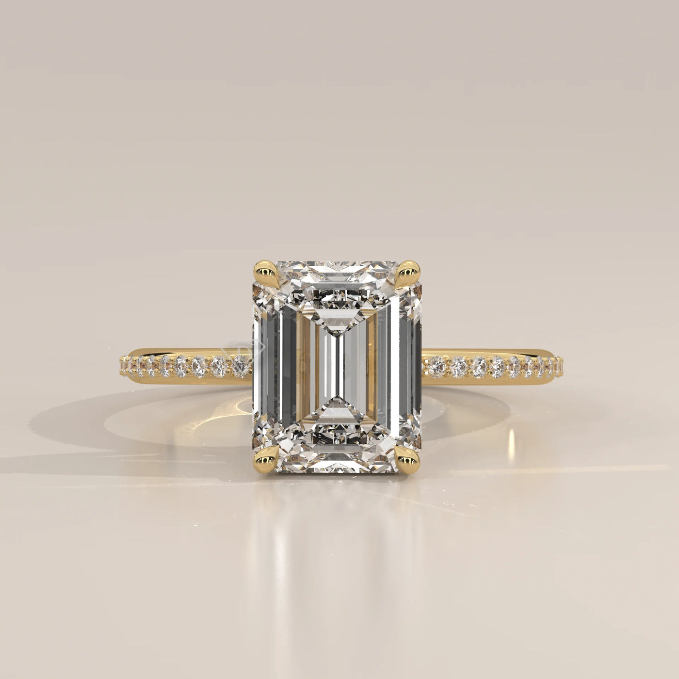 Emerald cut diamond ring with pavé band in yellow gold.