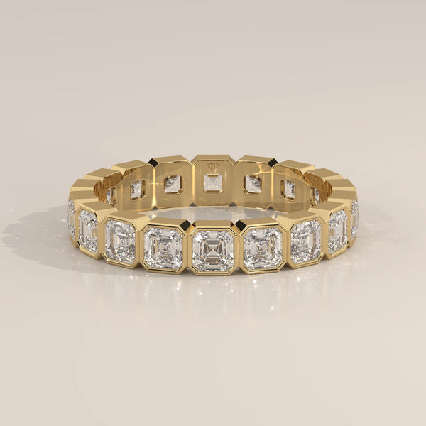 Square Emerald Cut Lab Grown Diamond Bezel Set Eternity Band in yellow gold, shown at an angle.
