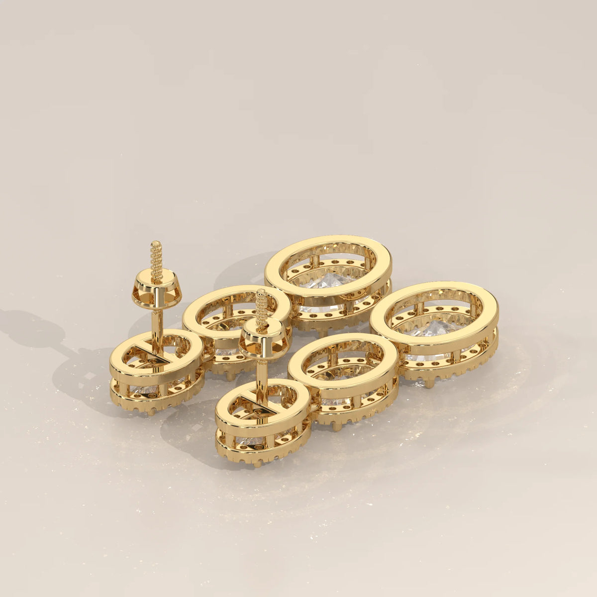 Graduated Three Oval Halo Lab Grown Diamond Drop Earrings in yellow gold, shown on a plain background.