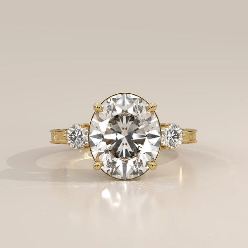 Karly 5 Carat Oval Lab Grown Diamond Three Stone Ring, Engraved Band in yellow gold, photographed head-on.