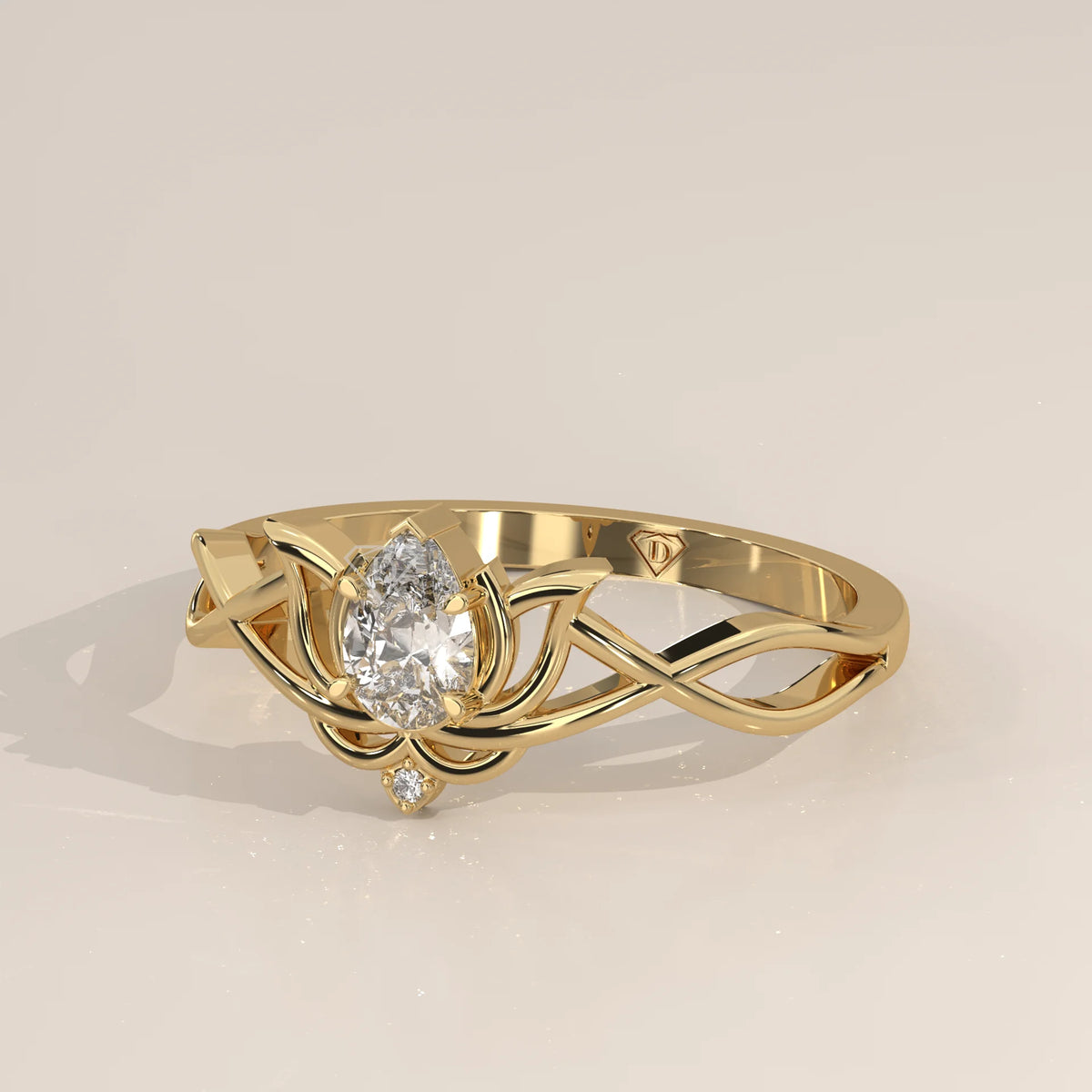A delicate gold ring featuring a pear-shaped diamond in a lotus design with intertwined band.