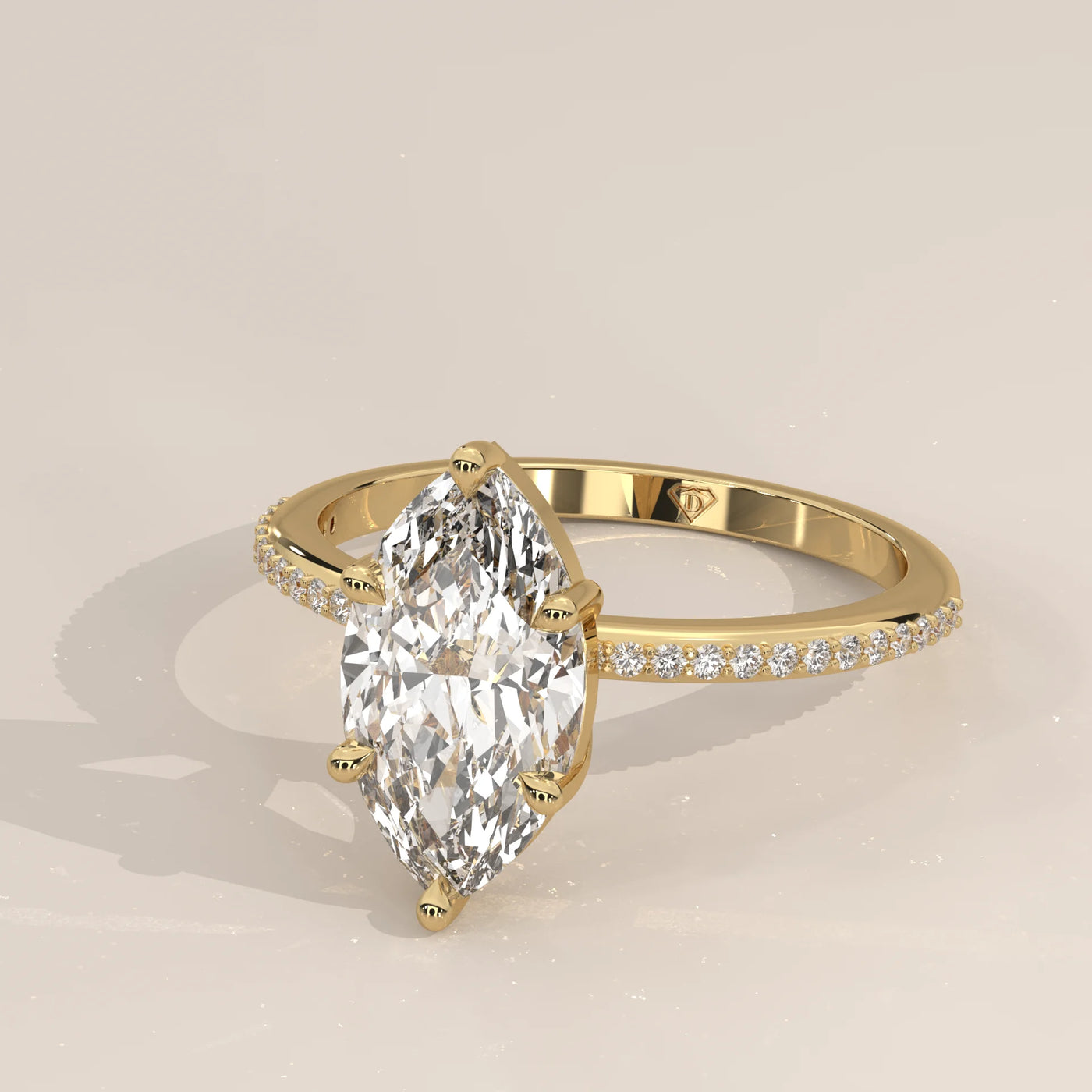 18k yellow gold engagement ring with a marquise cut diamond and pave band