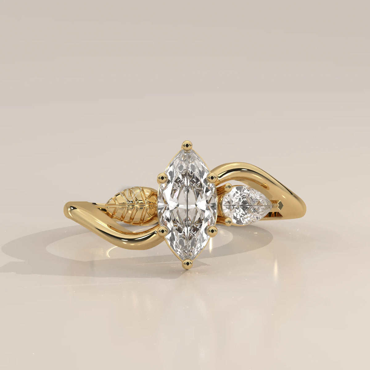 A 14k yellow gold ring featuring a marquise cut diamond and a pear shape diamond.