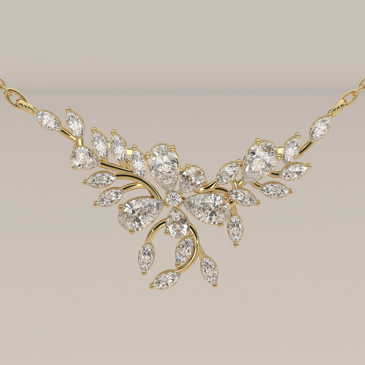 A marquise and pear lab grown diamond leaf necklace in yellow gold, front view on a plain background.