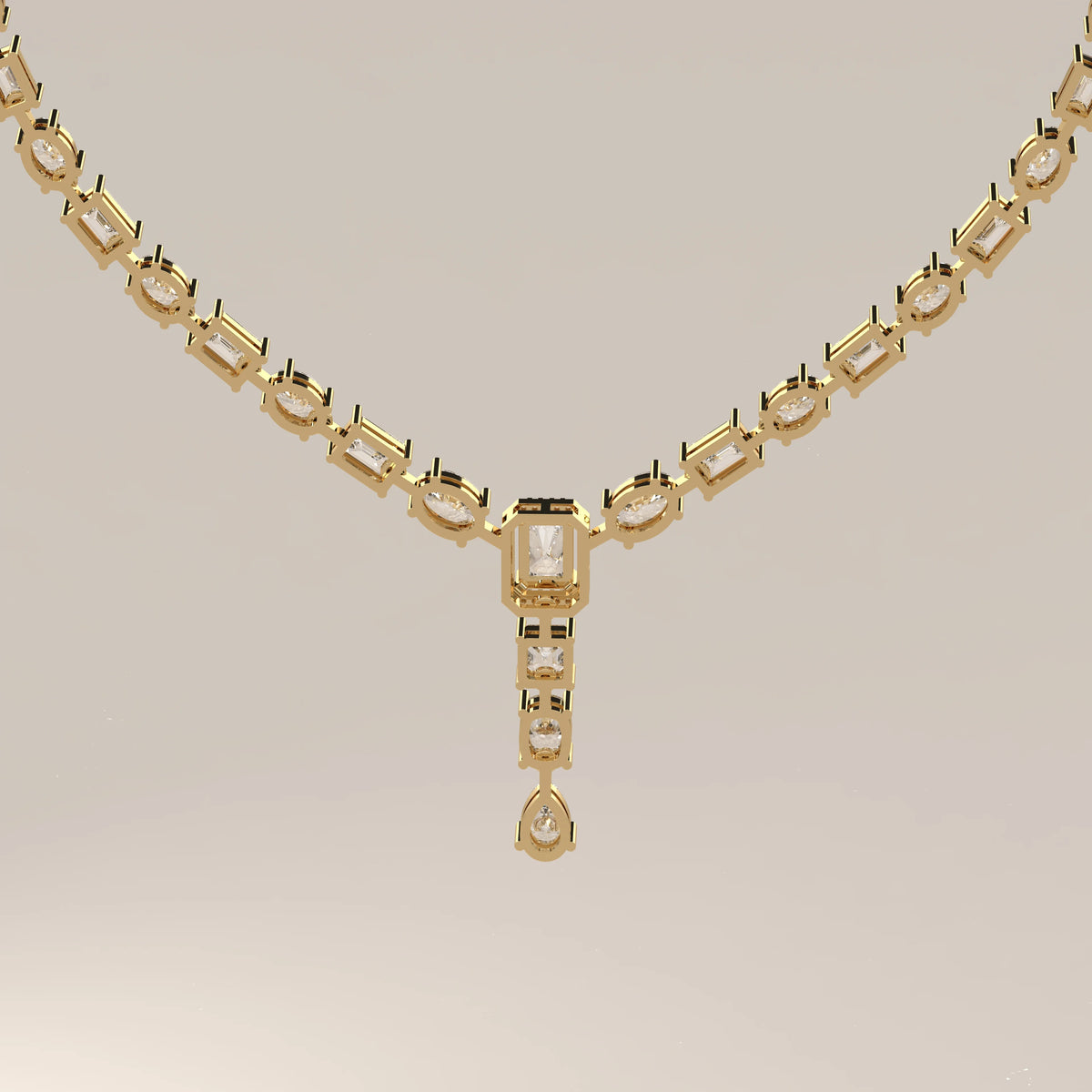 An emerald cut halo y-drop lab grown diamond necklace in yellow gold, shown on a plain background.