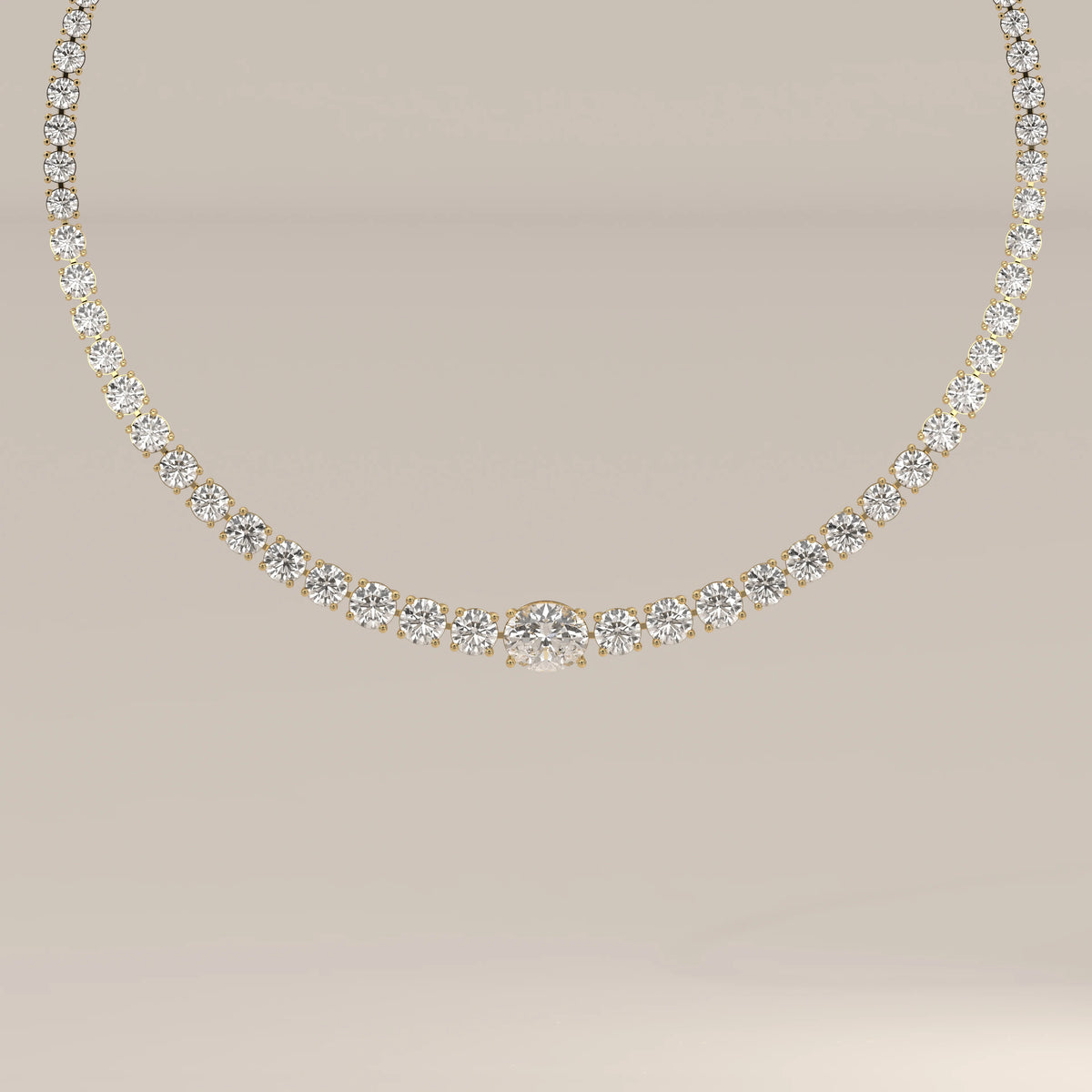 A graduated round lab grown diamond tennis necklace in yellow gold, shown from the front.