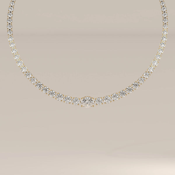 A graduated round lab grown diamond tennis necklace in yellow gold, shown from the front.