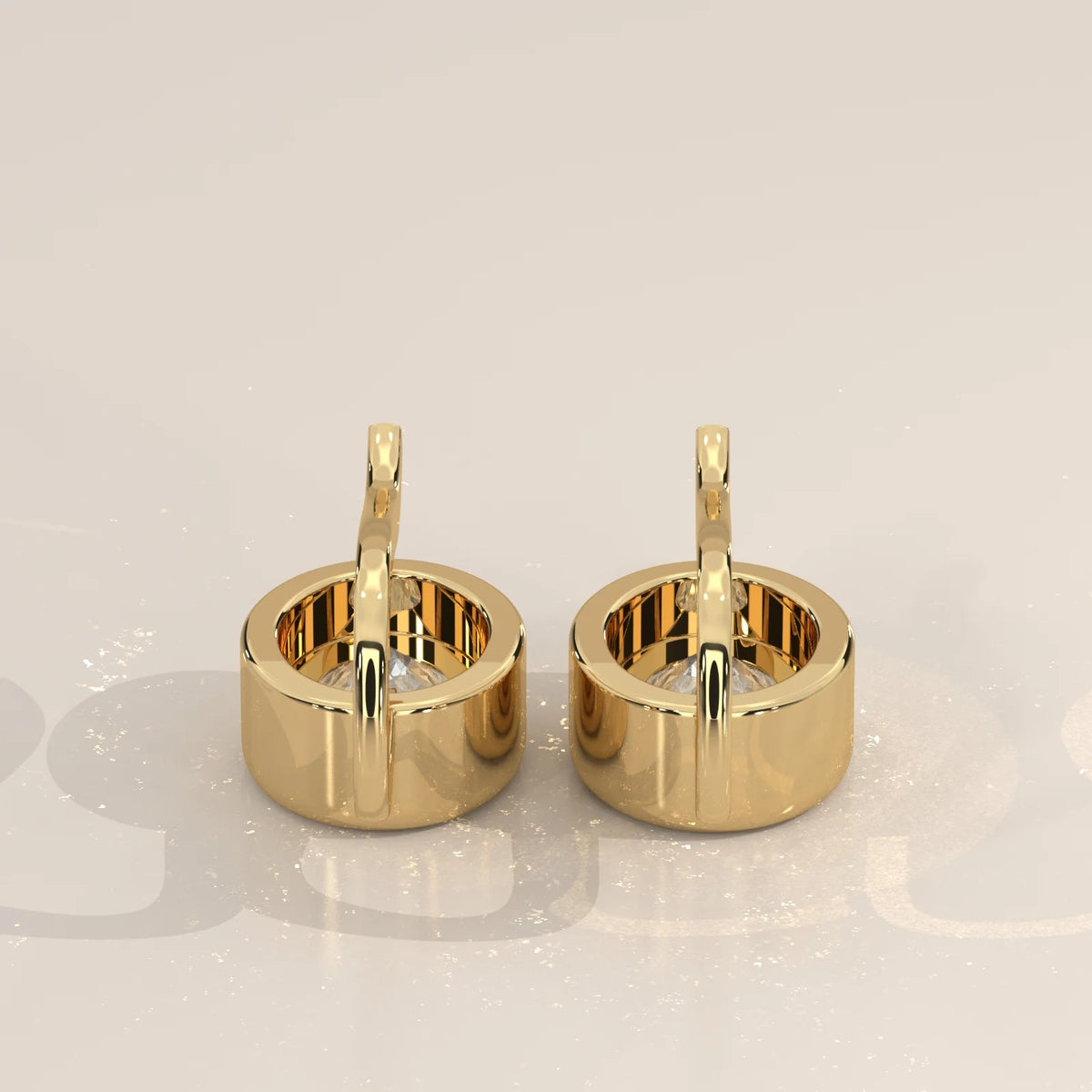Oval Bezel Set Lab Grown Diamond Drop Earrings on a Gold Hook in yellow gold, photographed at a three-quarter angle.