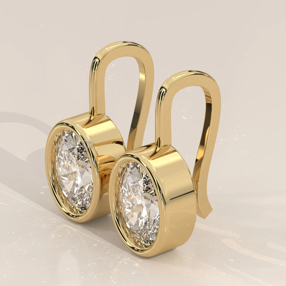 Oval Bezel Set Lab Grown Diamond Drop Earrings on a Gold Hook in yellow gold, shown at an angle.