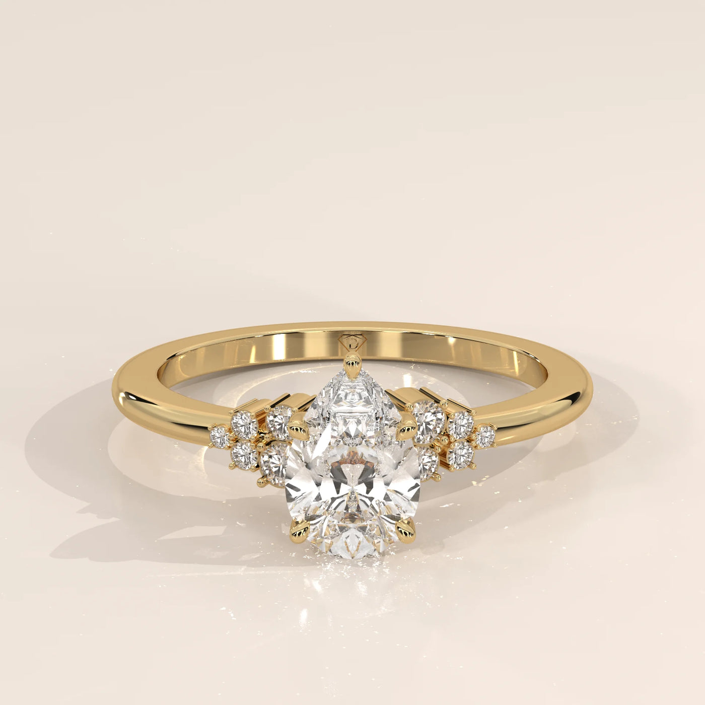 A yellow gold ring with a pear-cut diamond and smaller accent stones.