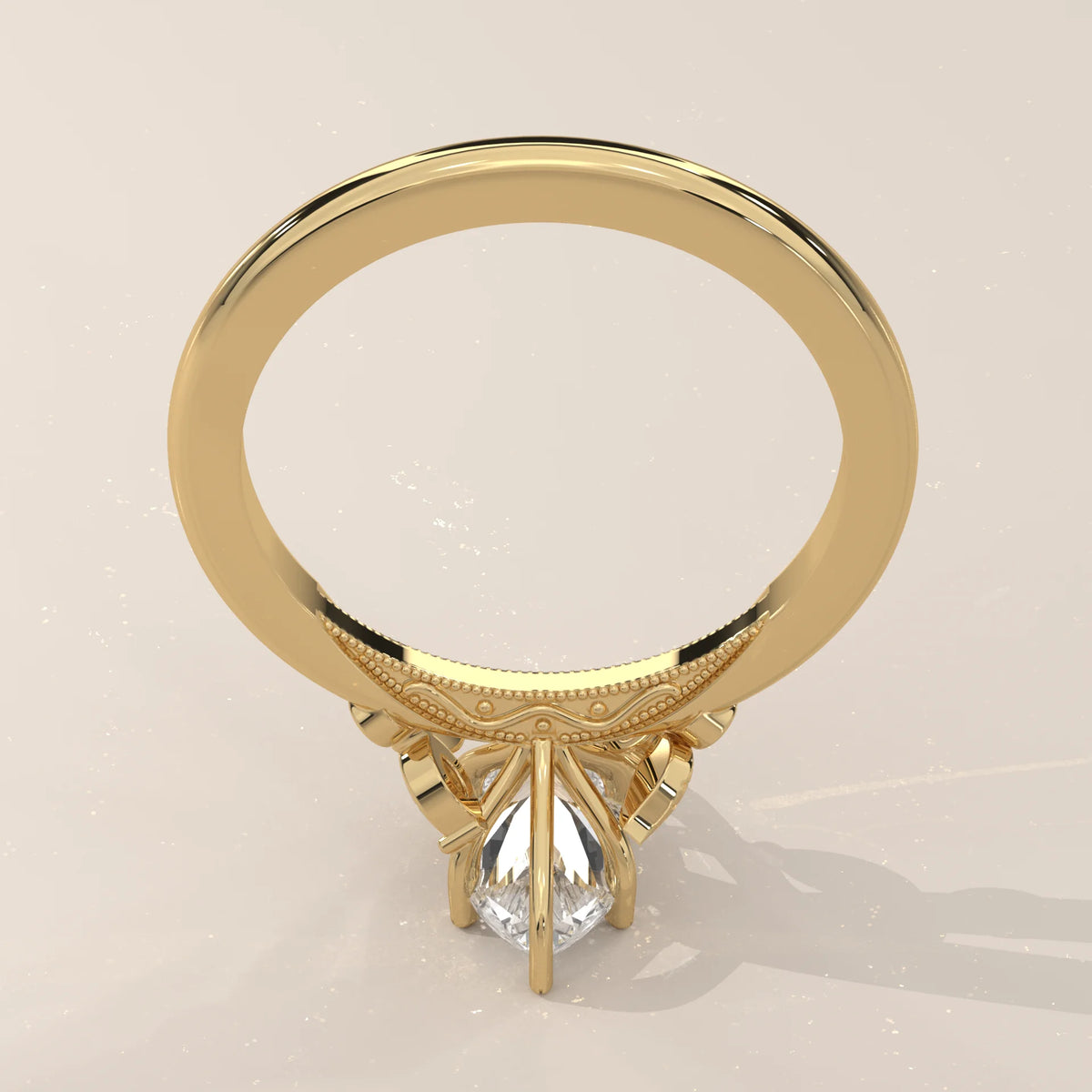 Gold ring with a pear-cut diamond and intricate detailing.