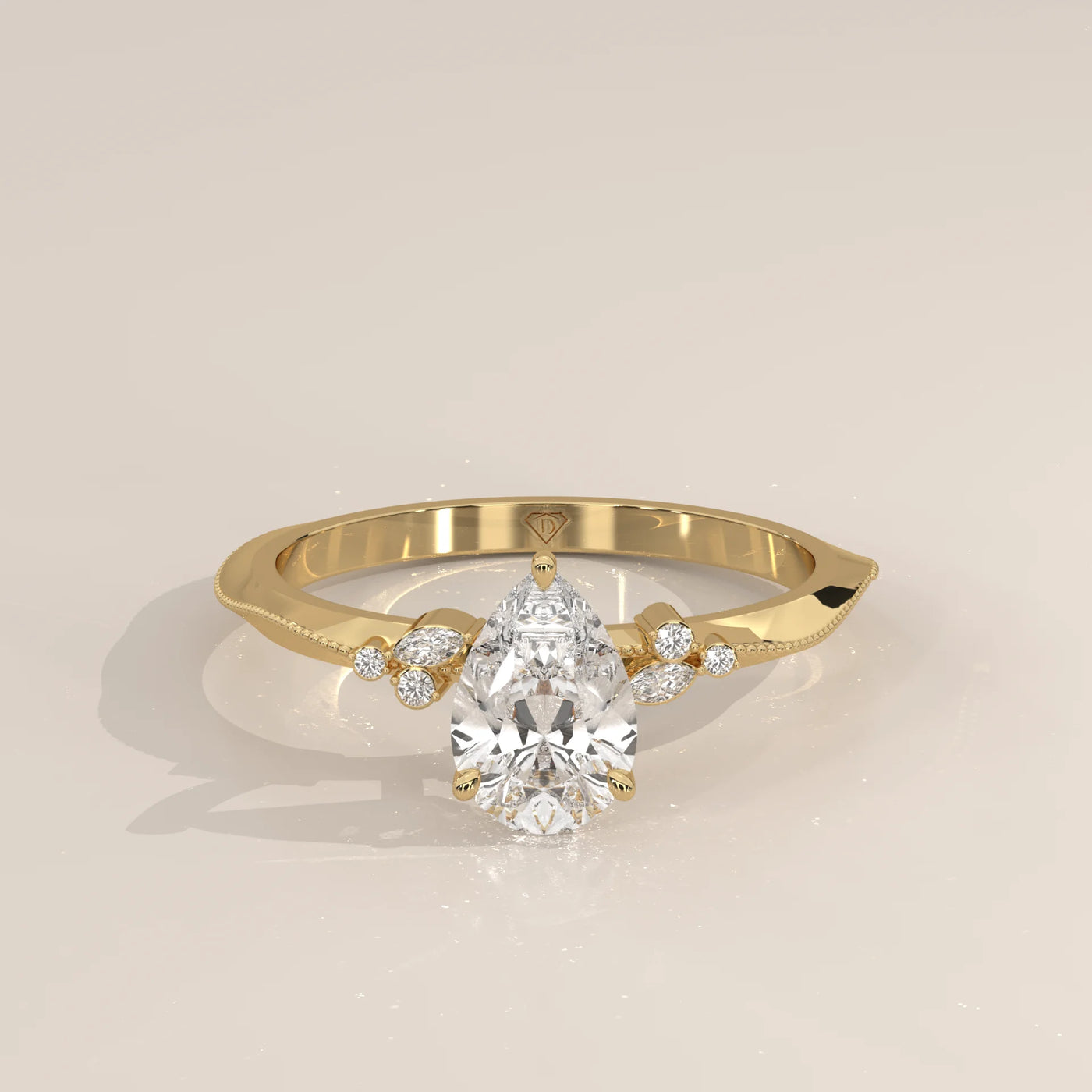 Elegant pear-cut diamond engagement ring in yellow gold with side stone accents.