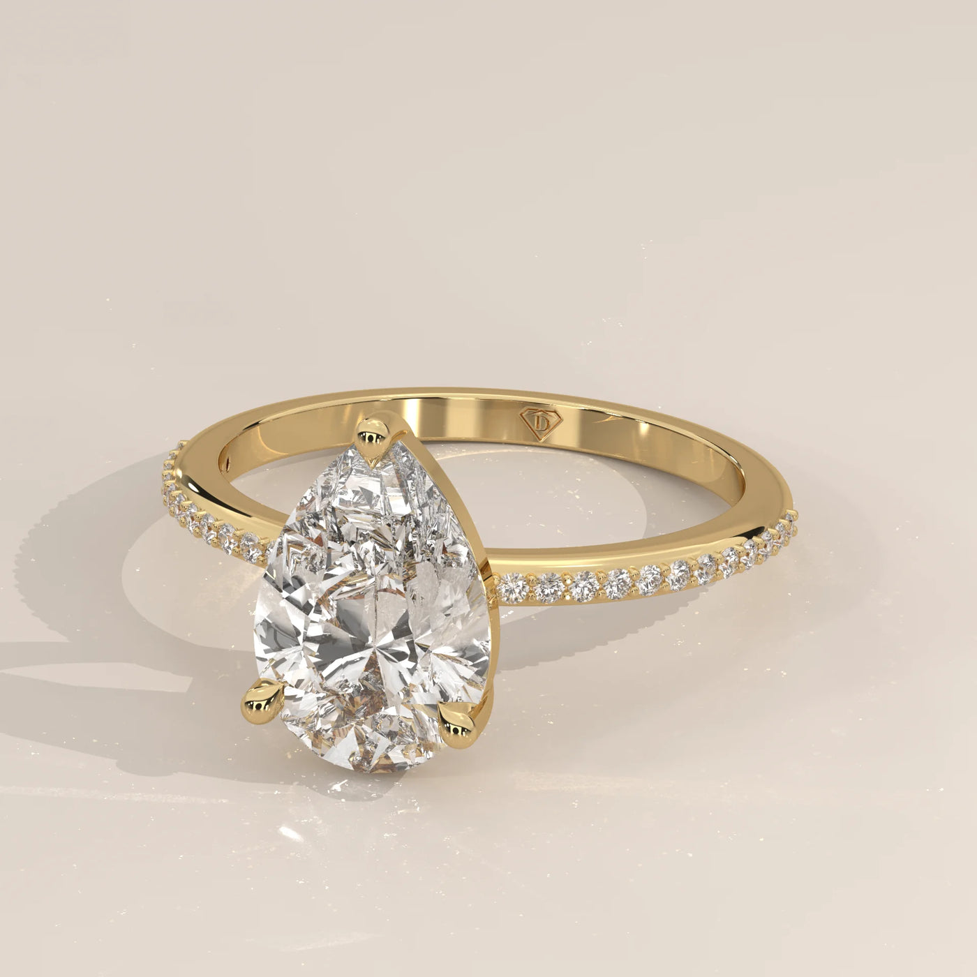 A yellow gold ring with a pear-cut diamond and small stones on the band.