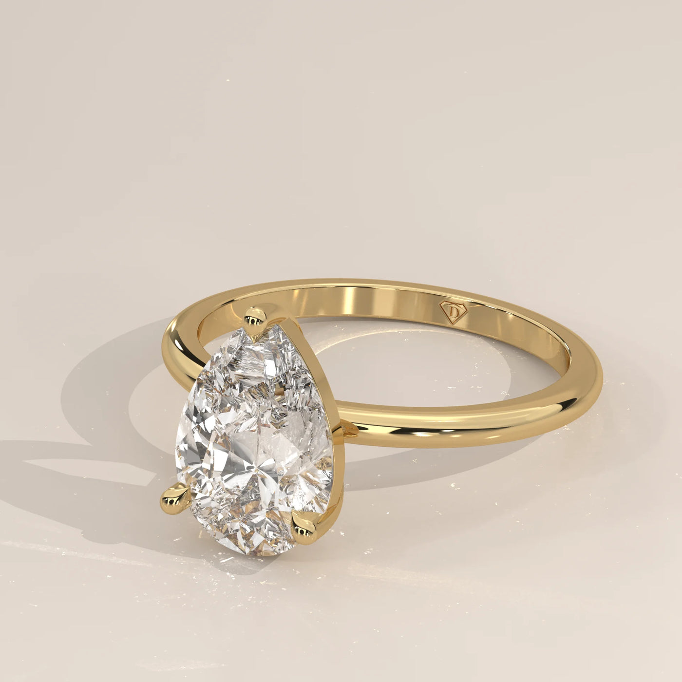 A classic 14k gold ring with a single pear-cut diamond.