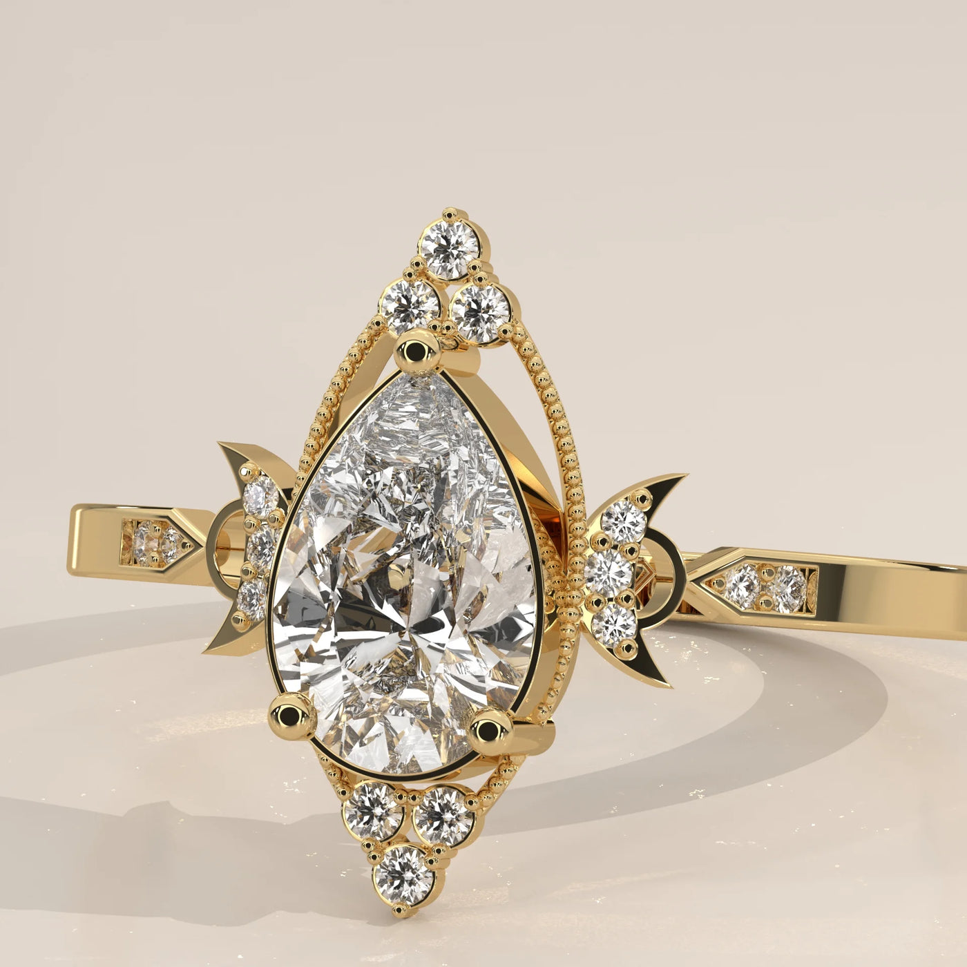 A pear-cut diamond engagement ring in yellow gold with intricate detailing.