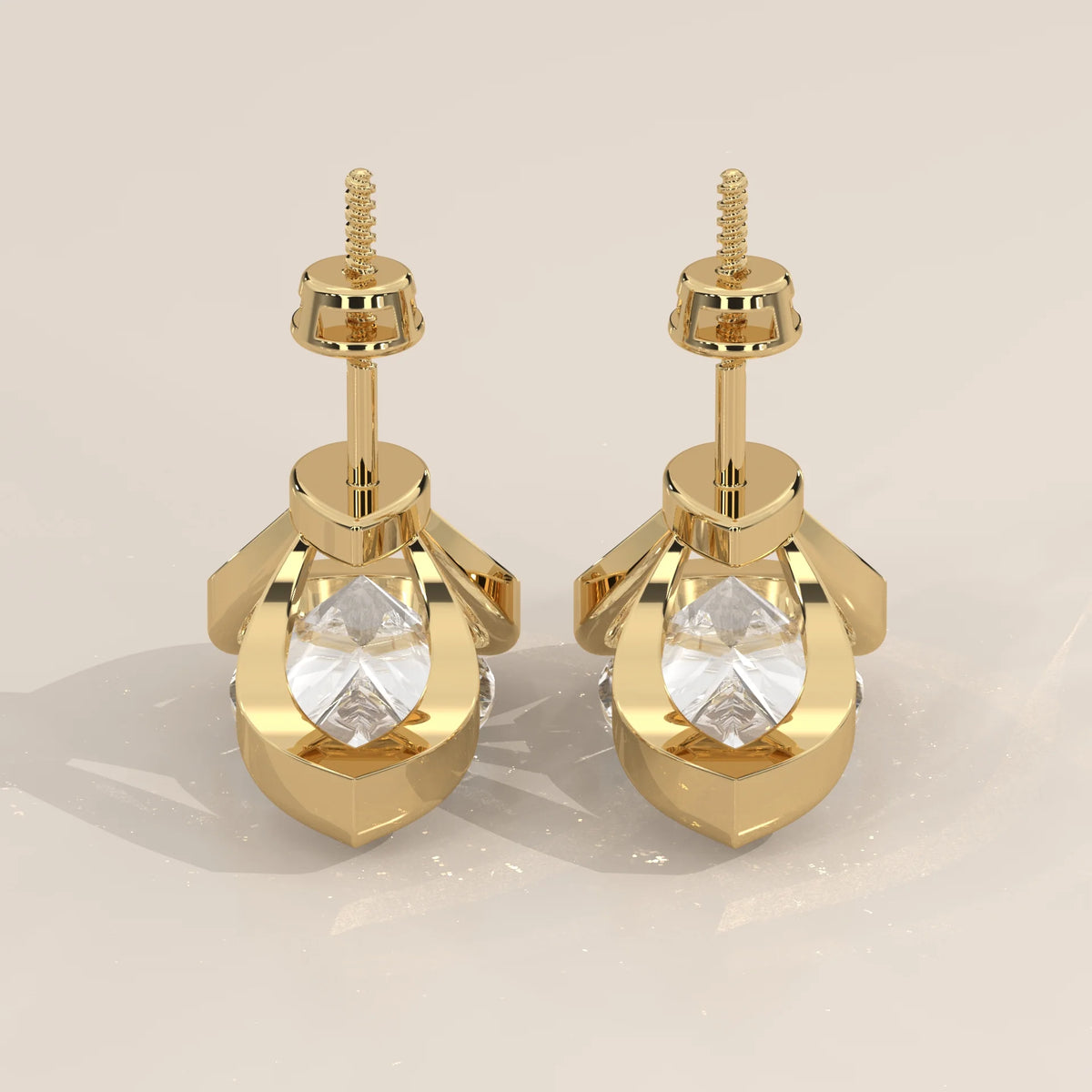 Pear Lab Grown Diamond Studs in a Curving Open Bezel in yellow gold, studio photograph on a plain background.