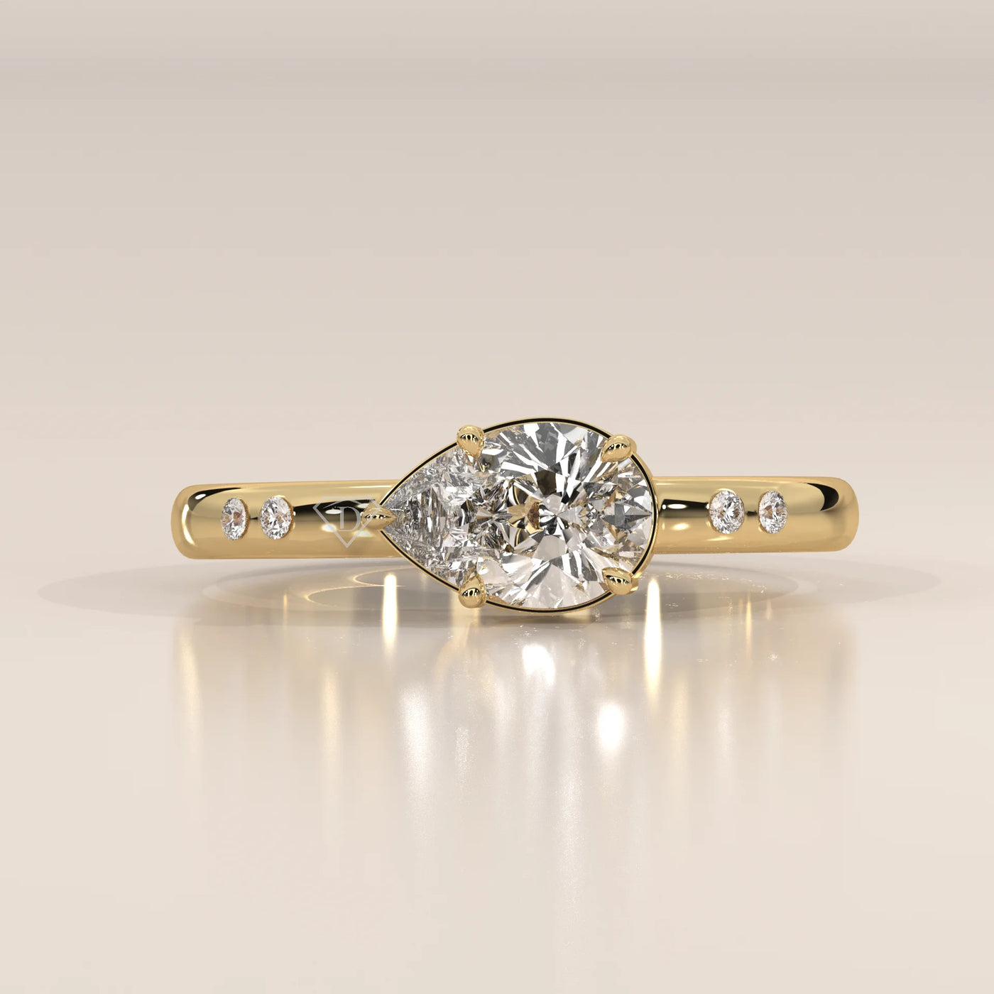 A yellow gold ring with a pear-shaped diamond and accent stones.