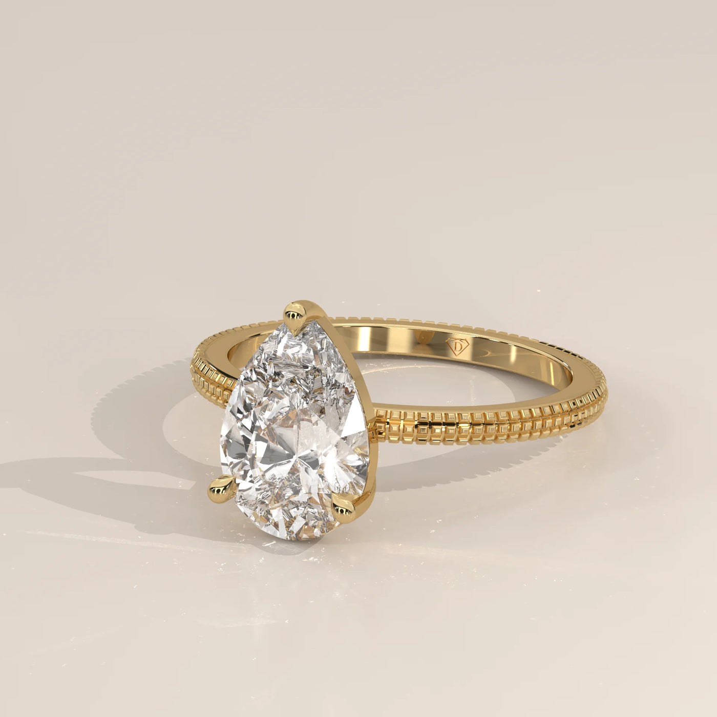 A delicate 14k gold ring with a pear-cut diamond and detailed band.