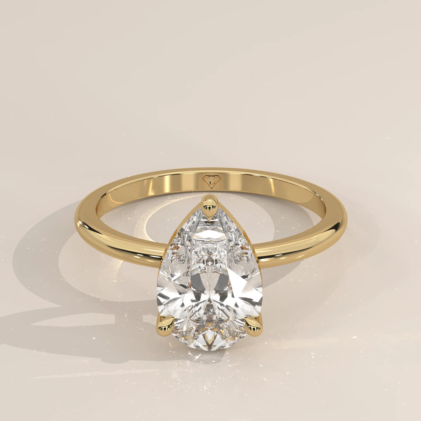 A classic solitaire engagement ring with a pear-shaped diamond in yellow gold.