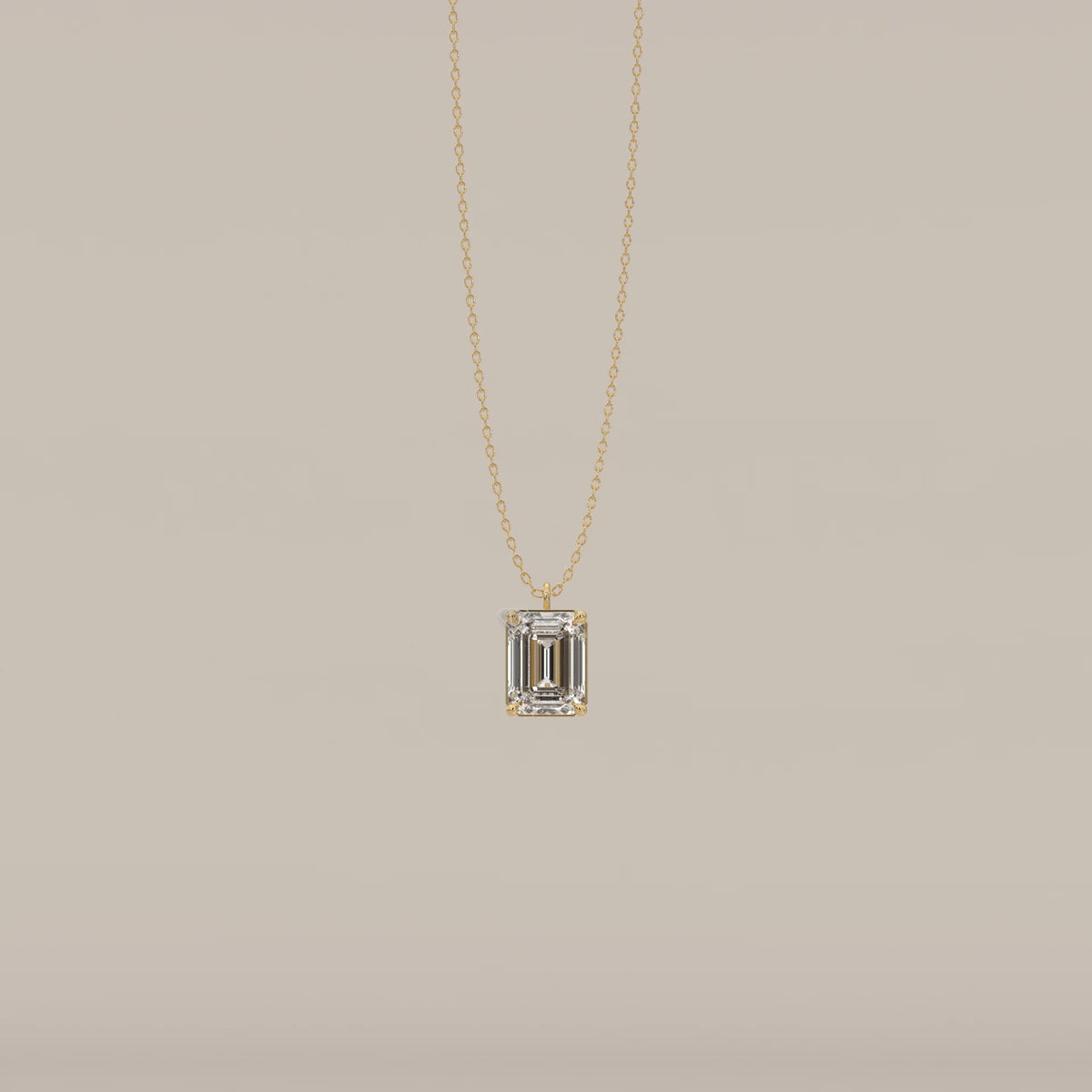 A gold pendant featuring an emerald-cut diamond.