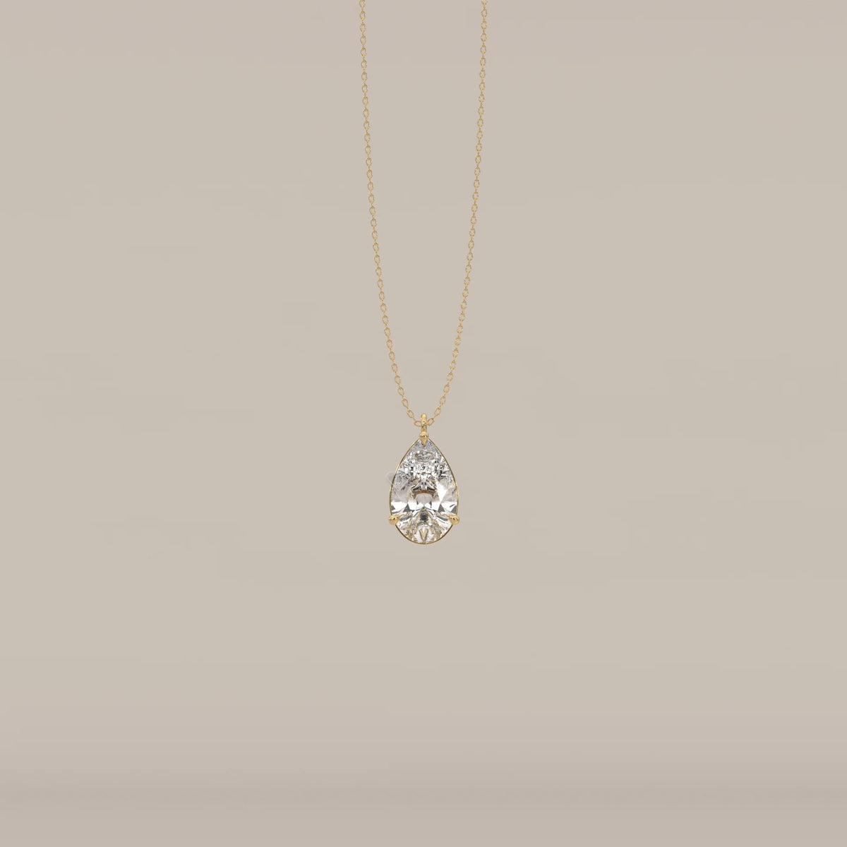 Gold pendant with a large, clear, teardrop-shaped faceted gemstone.