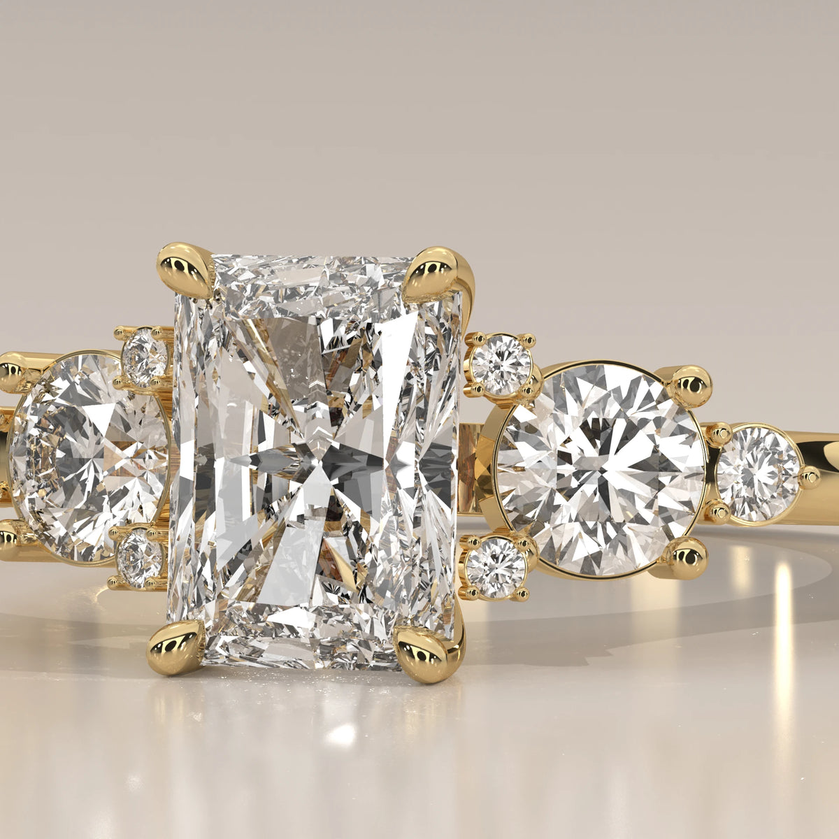 A radiant cut diamond ring with smaller accent stones in yellow gold.
