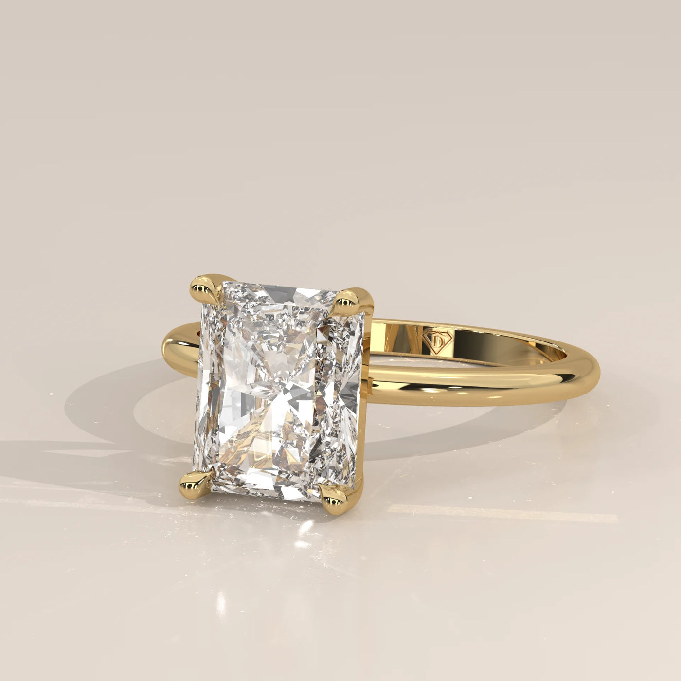 A radiant cut diamond engagement ring in 14k yellow gold.