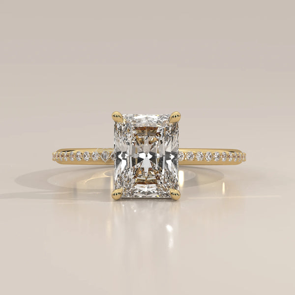 A classic 14k yellow gold ring with a radiant cut diamond and pave band.