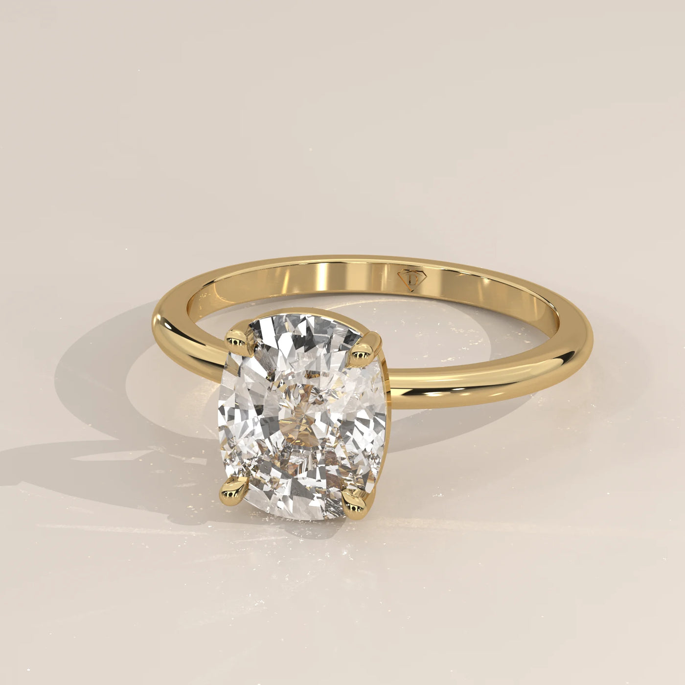 A cushion-cut diamond engagement ring in 14k yellow gold with pavé band.