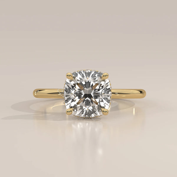 A cushion-cut diamond engagement ring in 14k yellow gold with pavé band.