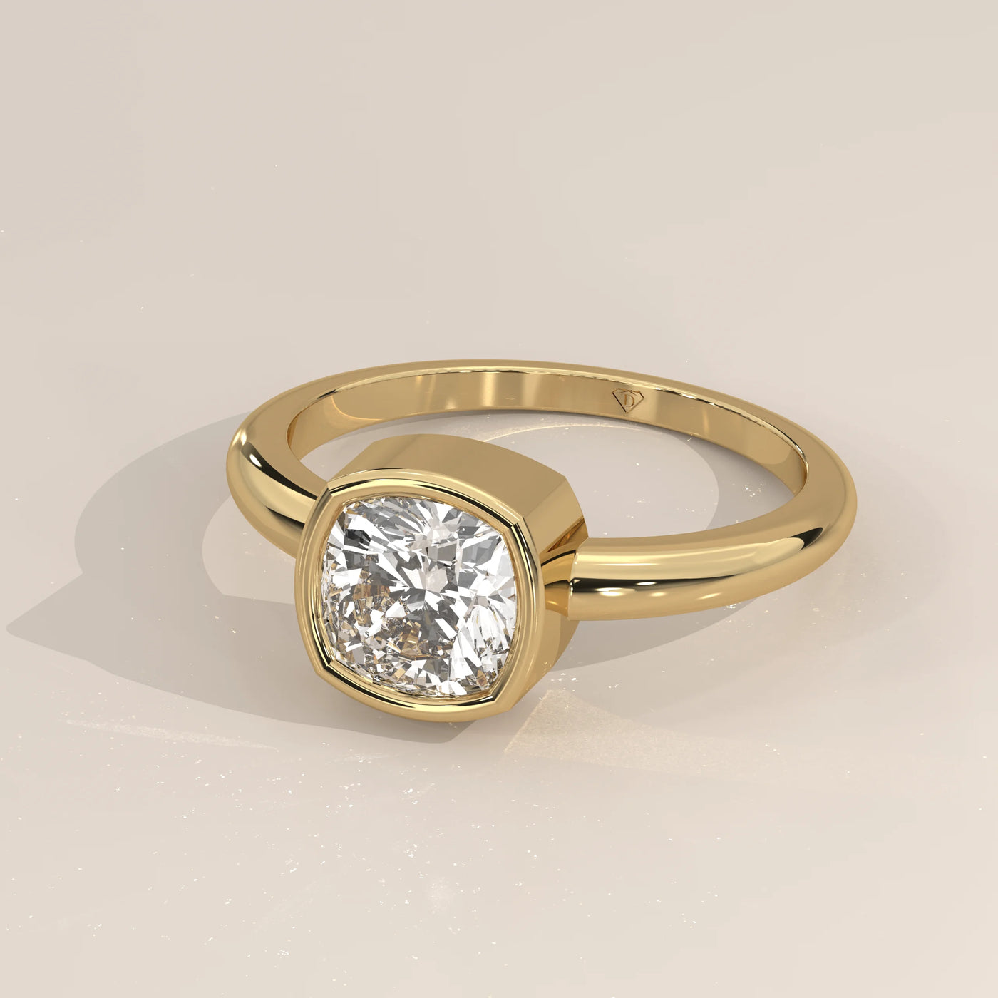Yellow gold ring with a cushion-cut diamond in a bezel setting.
