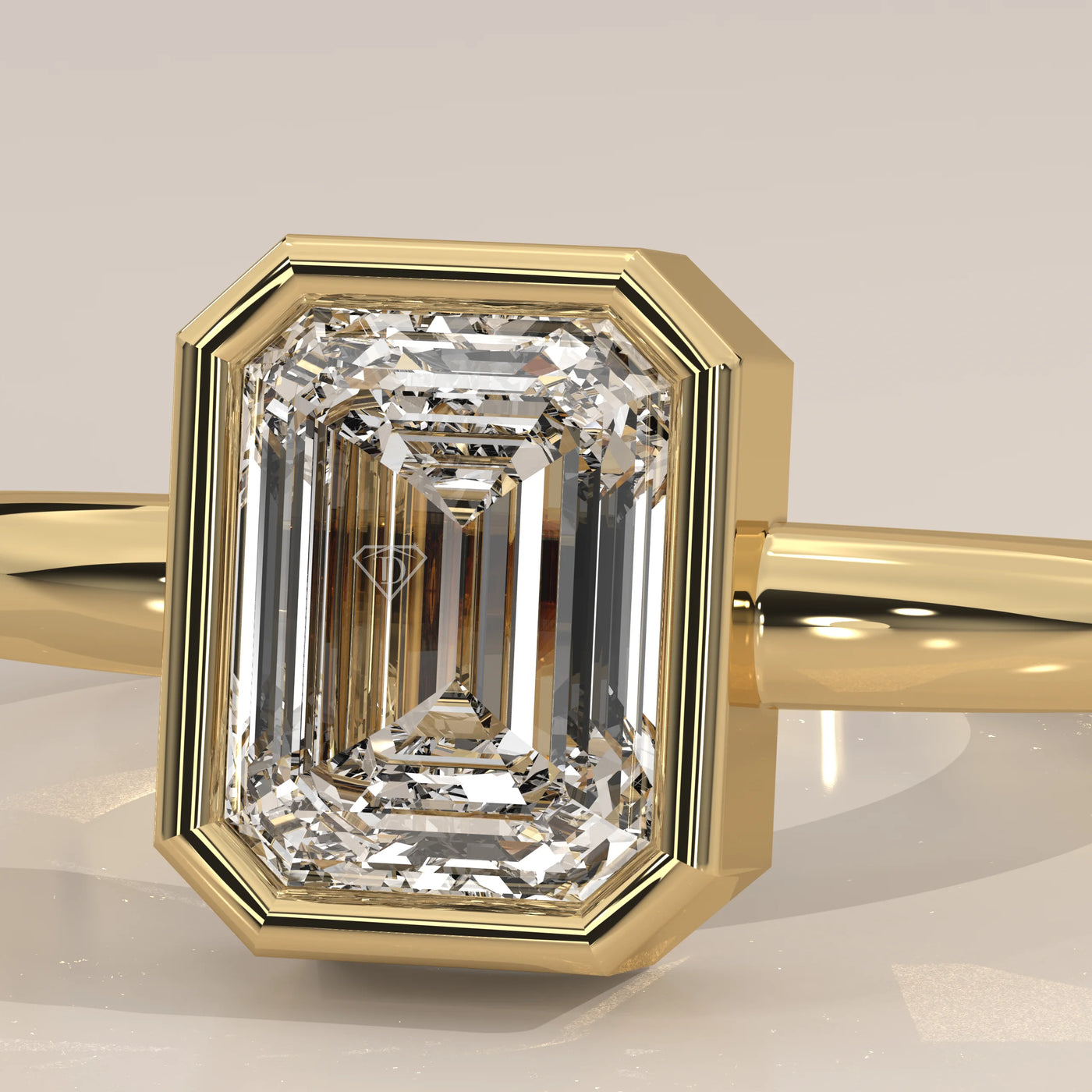 A yellow gold ring with an emerald-cut diamond in a bezel setting.