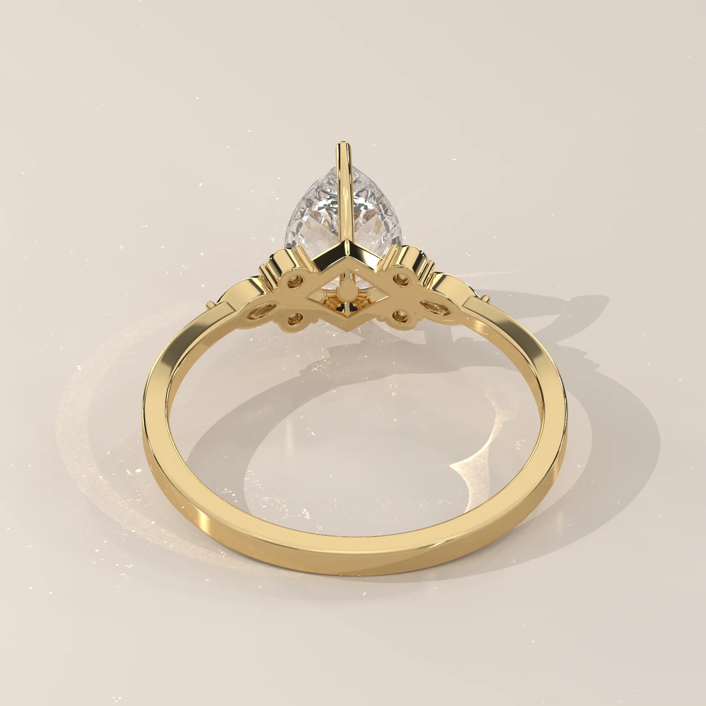 Yellow gold ring with a pear-cut diamond and delicate side detailing.