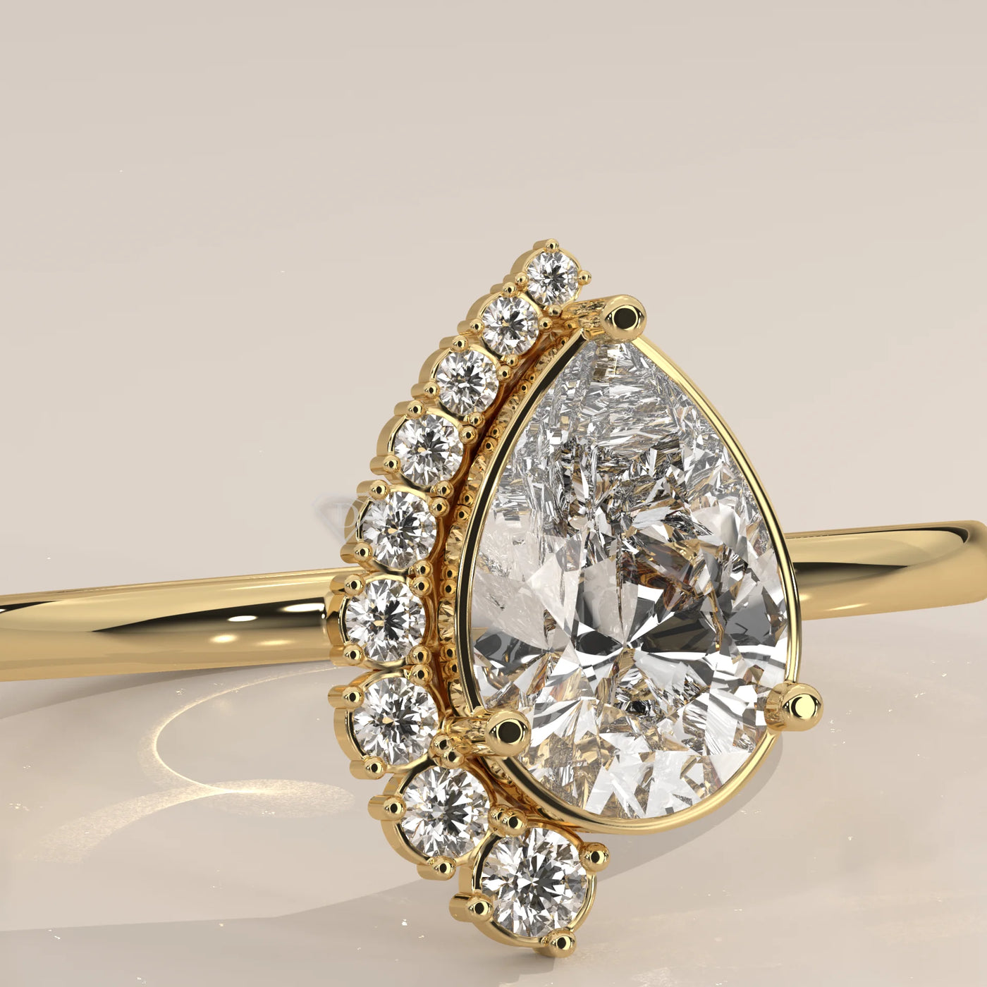 Gold ring with a pear-cut diamond and halo of smaller diamonds.