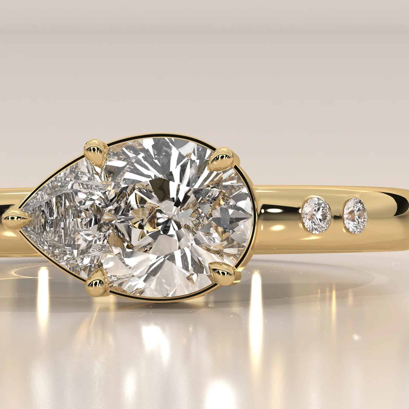 A close-up of a pear-shaped diamond ring in 14k gold with small accent diamonds.