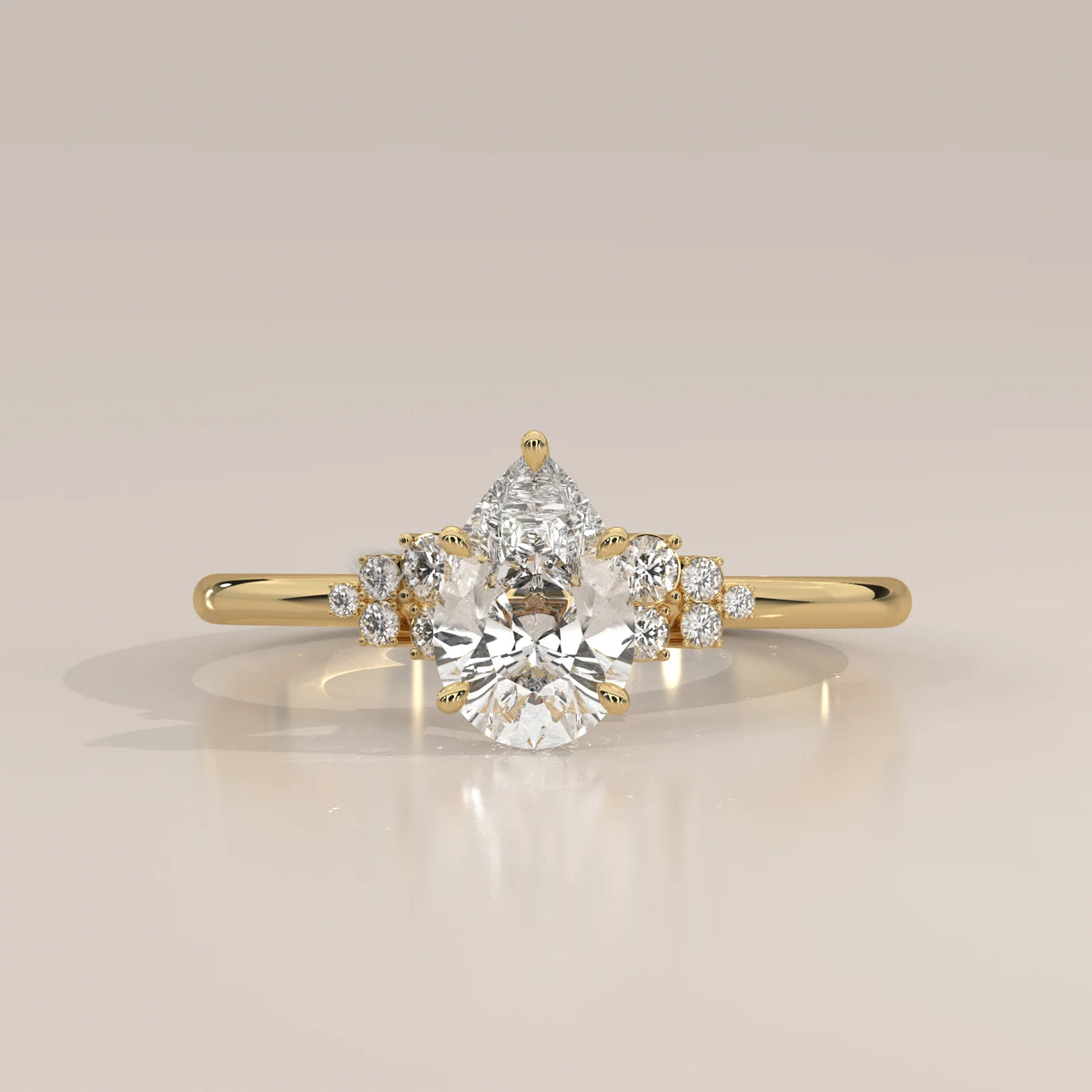 A delicate gold ring featuring a prominent pear-shaped diamond surrounded by smaller accent stones.