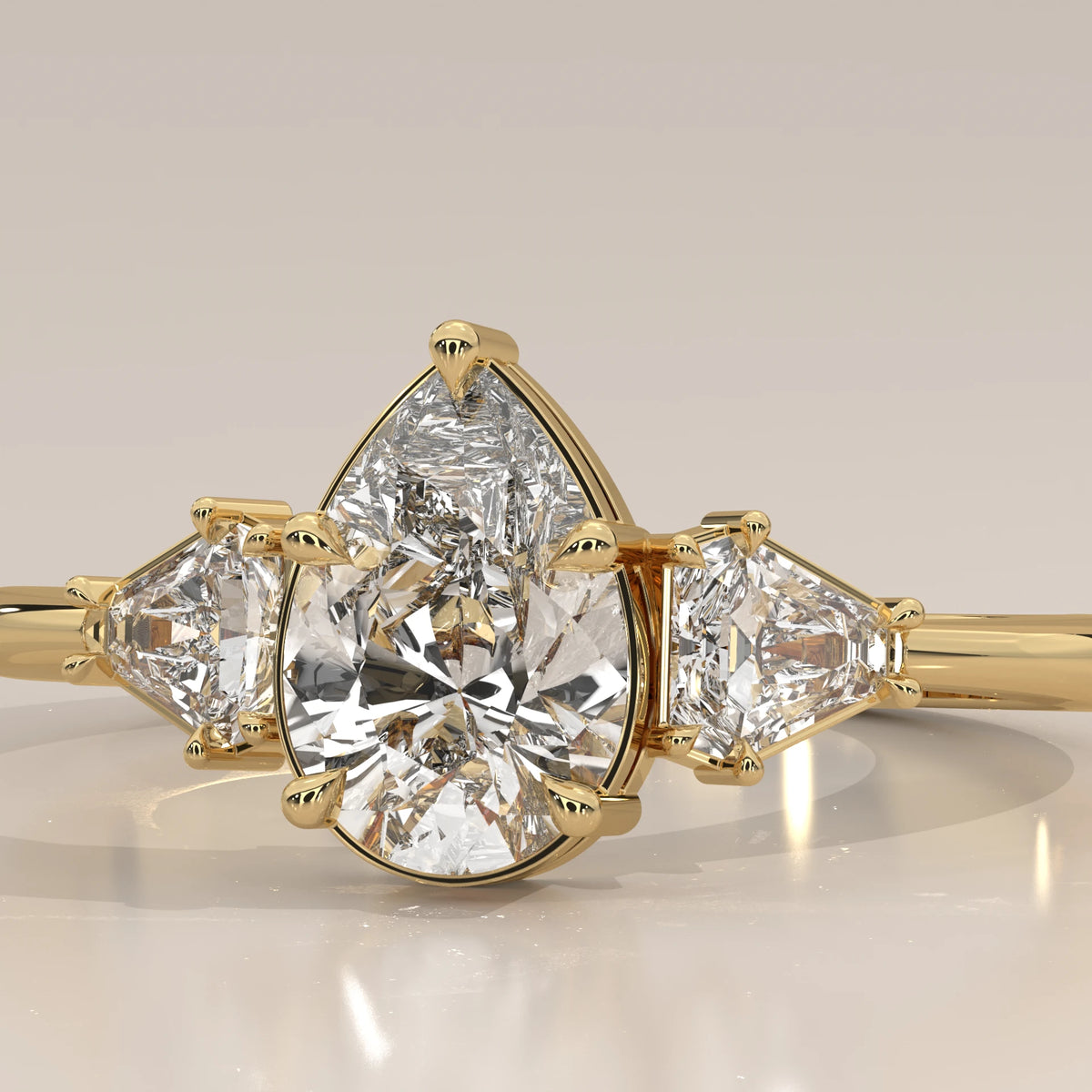 Pear Lab Grown Diamond Three Stone Ring with Shield Cut Sides in yellow gold, front view on a plain background.