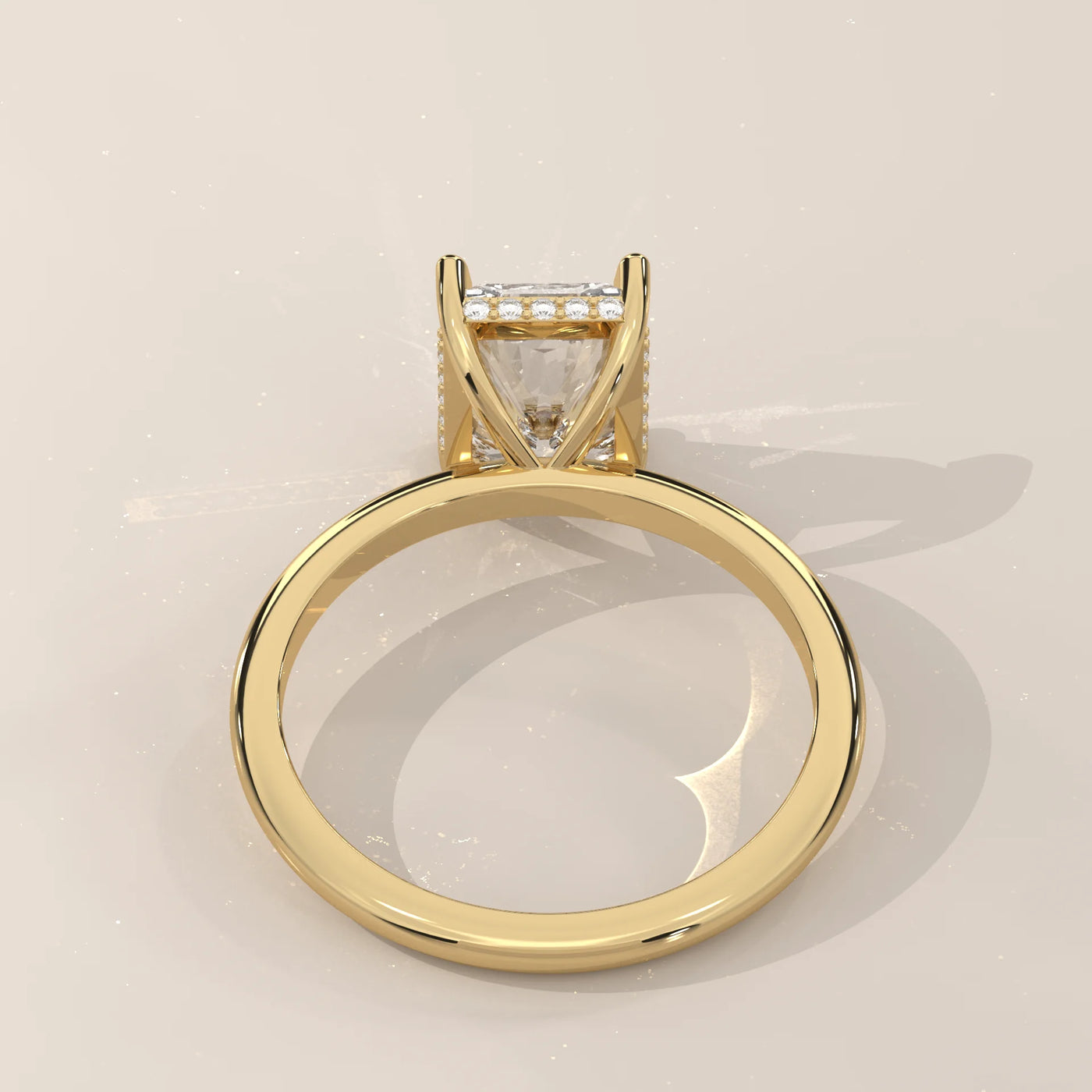 A princess-cut diamond engagement ring set in 14k yellow gold with pave detailing.