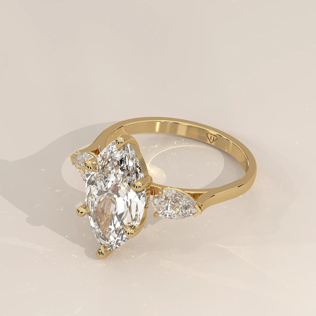 Umor 5 Carat Marquise Lab Grown Diamond Three Stone Ring, Pear Sides in yellow gold, shown from the side.