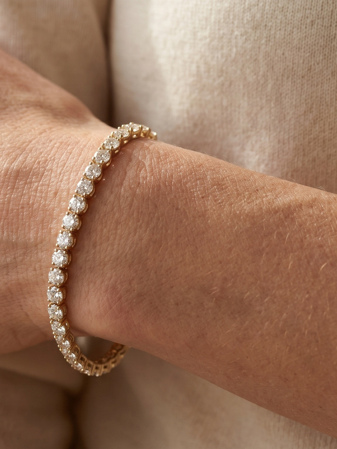 Woman's wrist wearing a diamond tennis bracelet