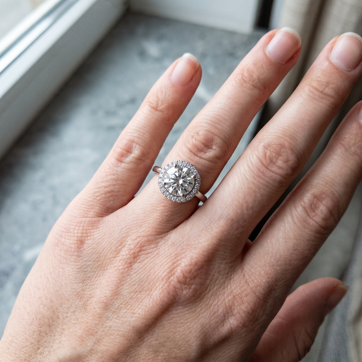 Halo engagement ring with a round centre diamond encircled by pave stones